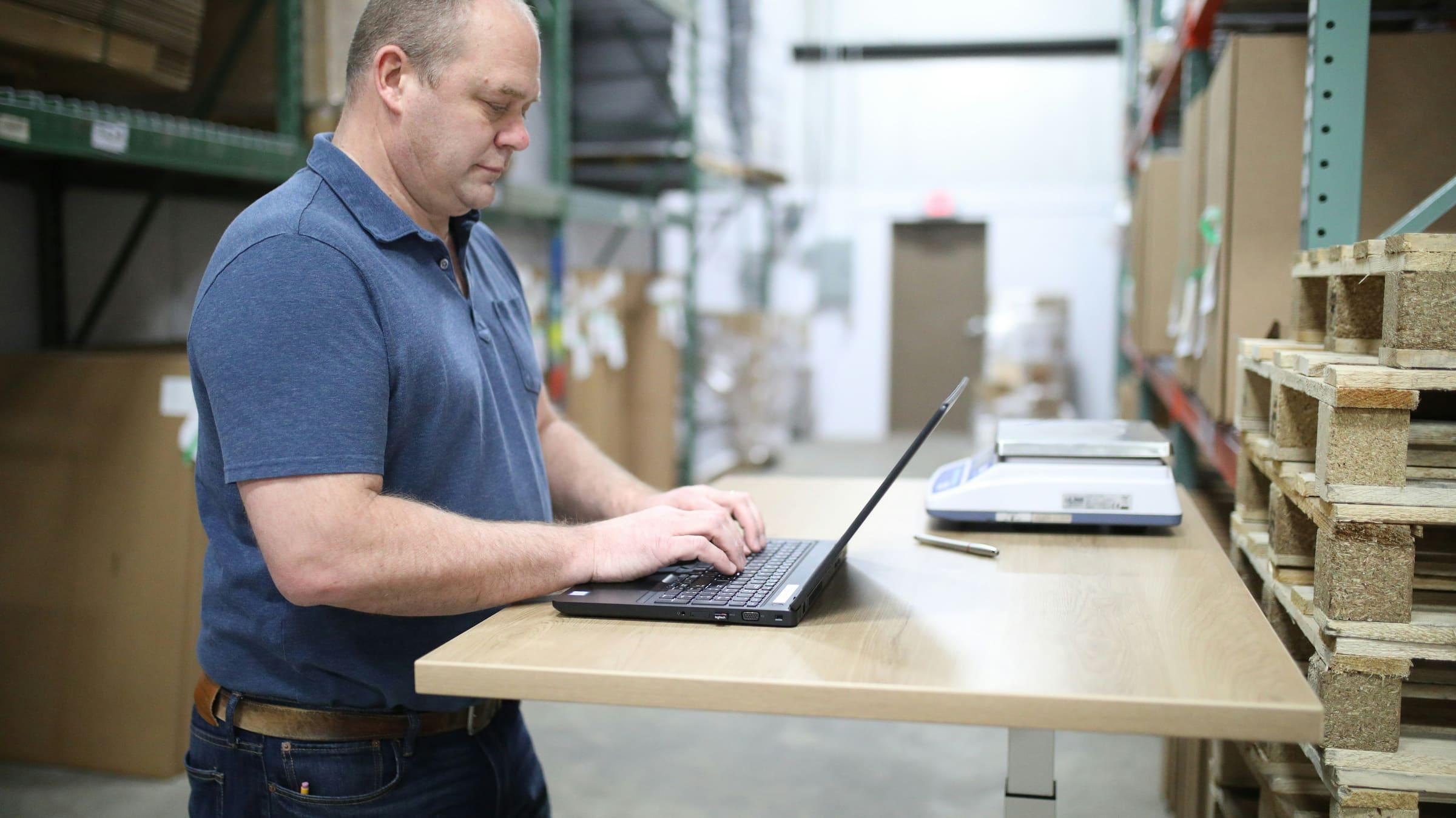 Laptop in a warehouse environment for logistics workflow coordination.
